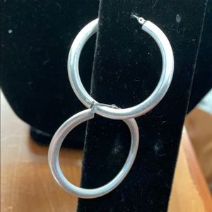 Silver tone hoop pierced earrings.